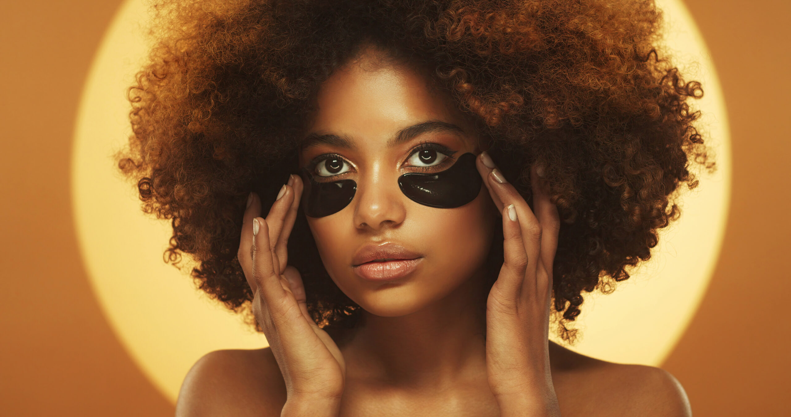 Young beautiful african woman standing, wearing eye patches against dark circles