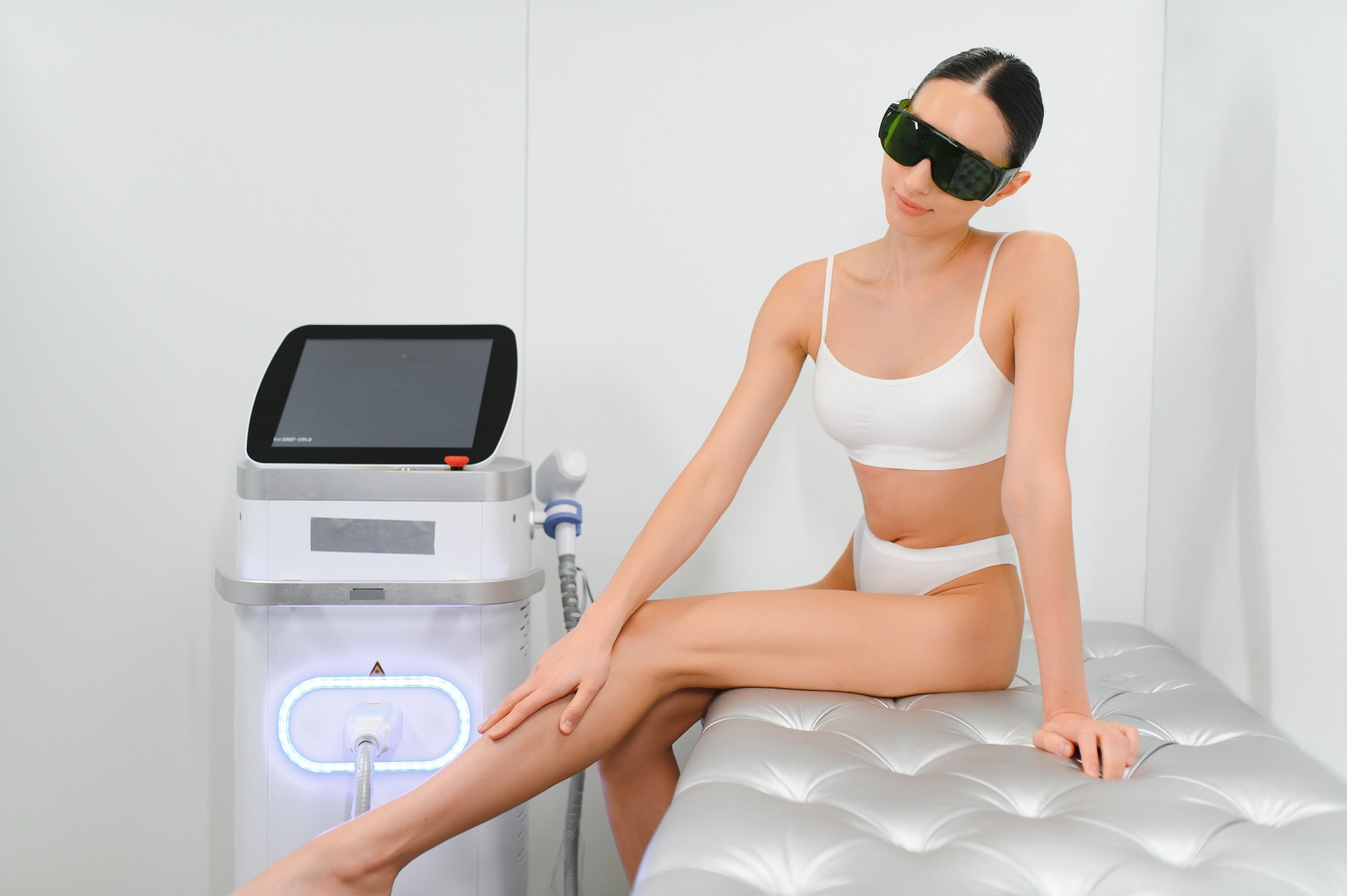 Happy young woman after laser hair removal. A woman near a laser depilation machine