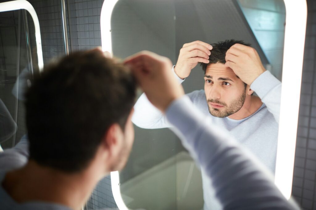 jeune homme souhaitant utiliser l'huile de ricin après une greffe de cheveux. 