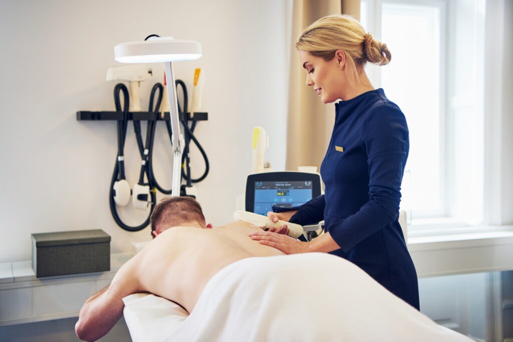 Man getting a laser hair removal treatment on his back