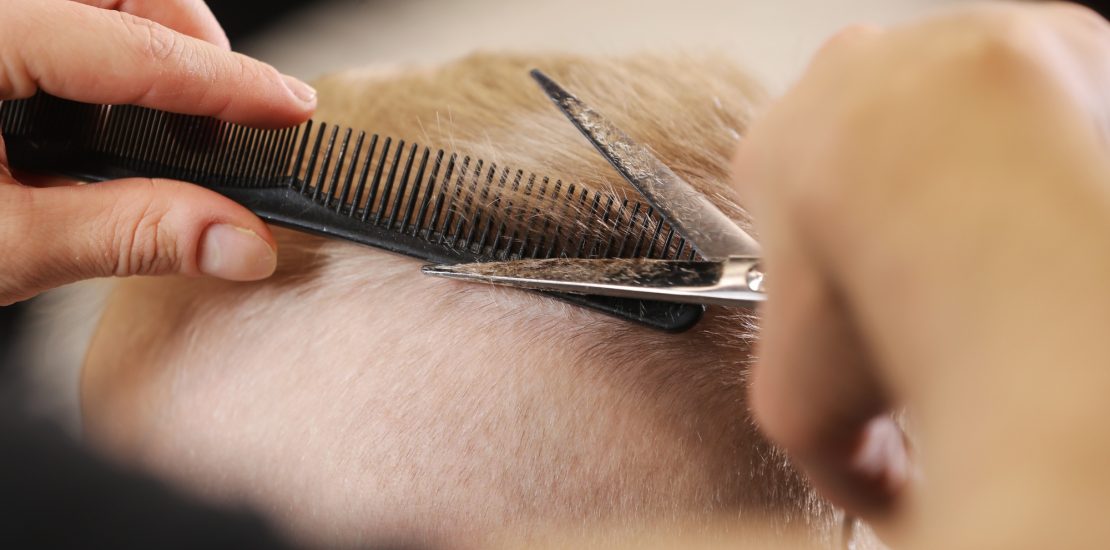 Men's hairstyling, haircutting, in a barber shop or hair salon.
